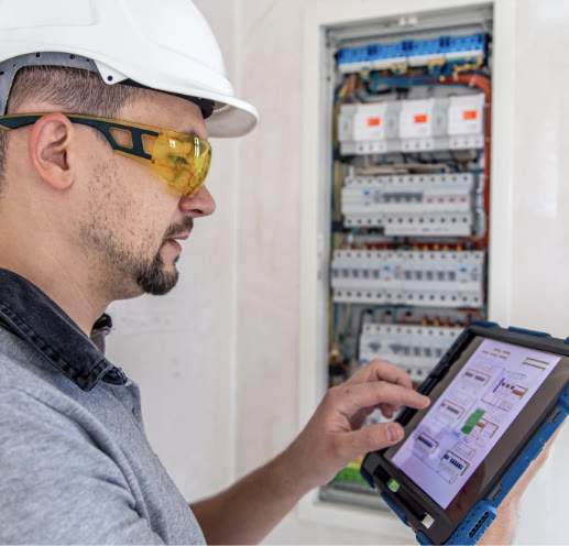 Técnico de postventa de Inmobiliaria FG revisando un tablero eléctrico